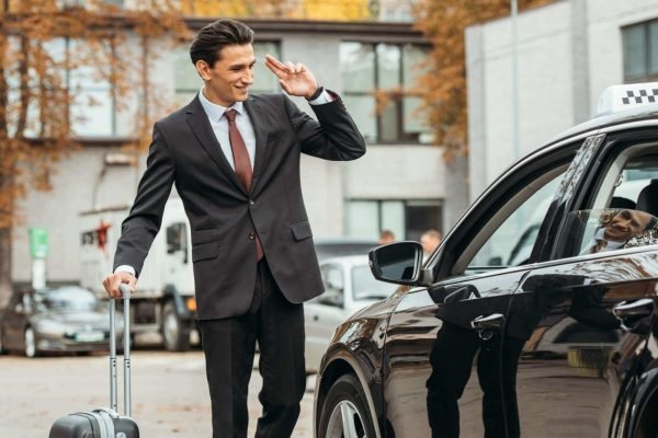 businessman-with-suitcase-smiling-to-taxi-driver-2024-11-12-00-46-47-utc-scaled-1.jpg