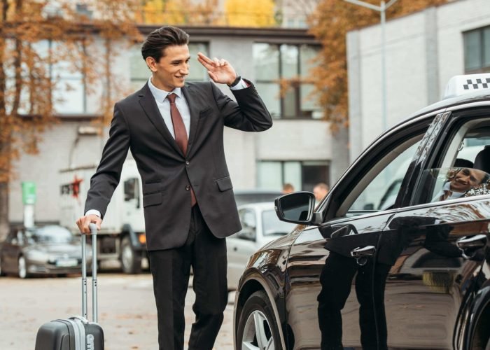 businessman-with-suitcase-smiling-to-taxi-driver-2024-11-12-00-46-47-utc