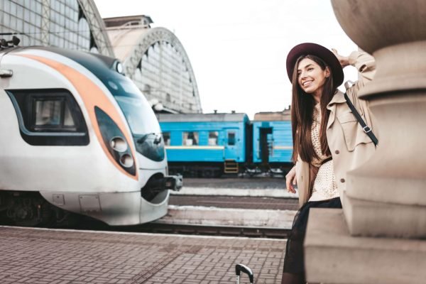 smiling-girl-in-hat-at-train-station-waiting-for-t-2024-10-18-08-21-08-utc